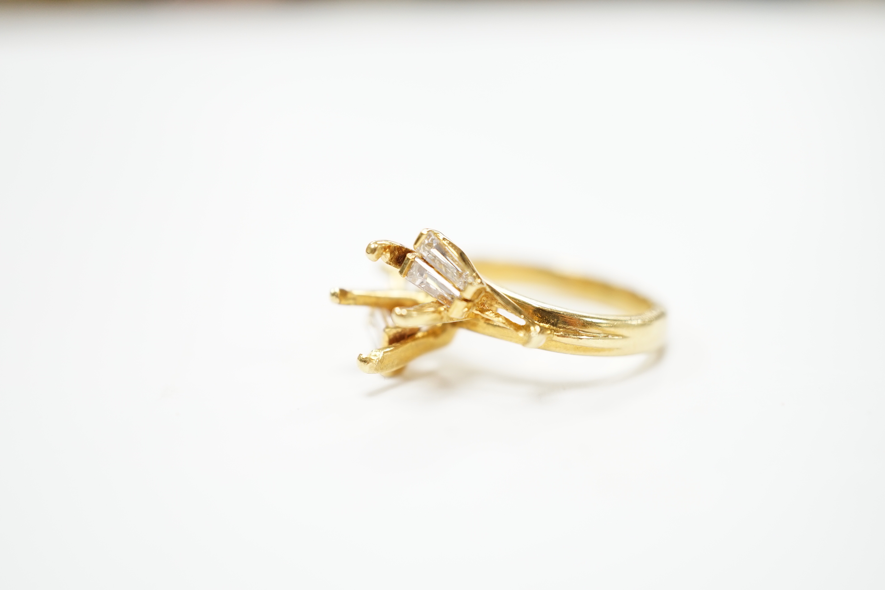 A modern 18ct gold and four stone trapeze cut diamond set crossover ring, size J, (central stone missing), size I/J, gross weight 4.6 grams.